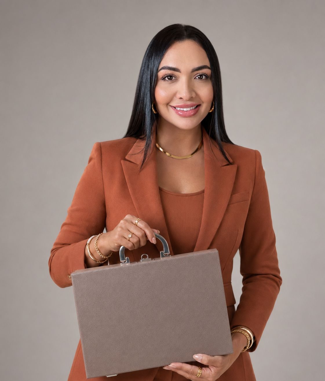 Representante da Anela de blazer terracota, segurando a maleta de peças.
